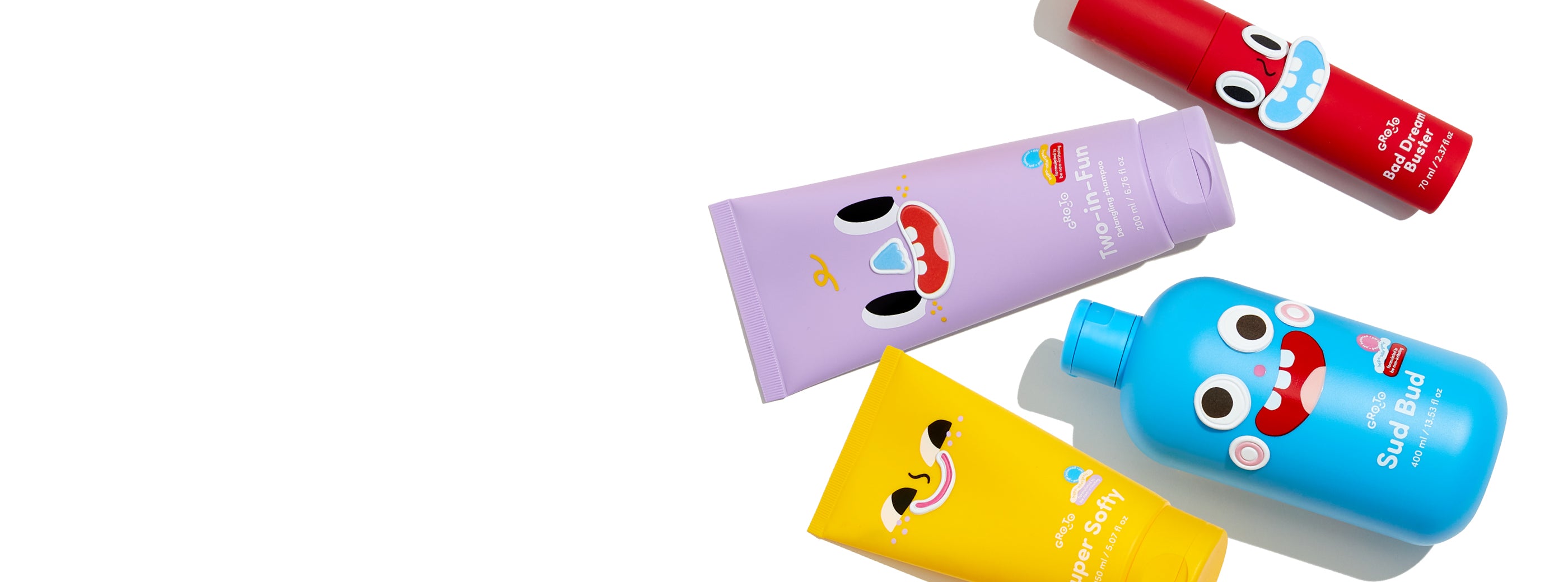 Four colorful skincare product bottles—yellow, purple, blue, and red—are decorated with playful cartoon faces and arranged diagonally on a white background. The left side of the image is empty.