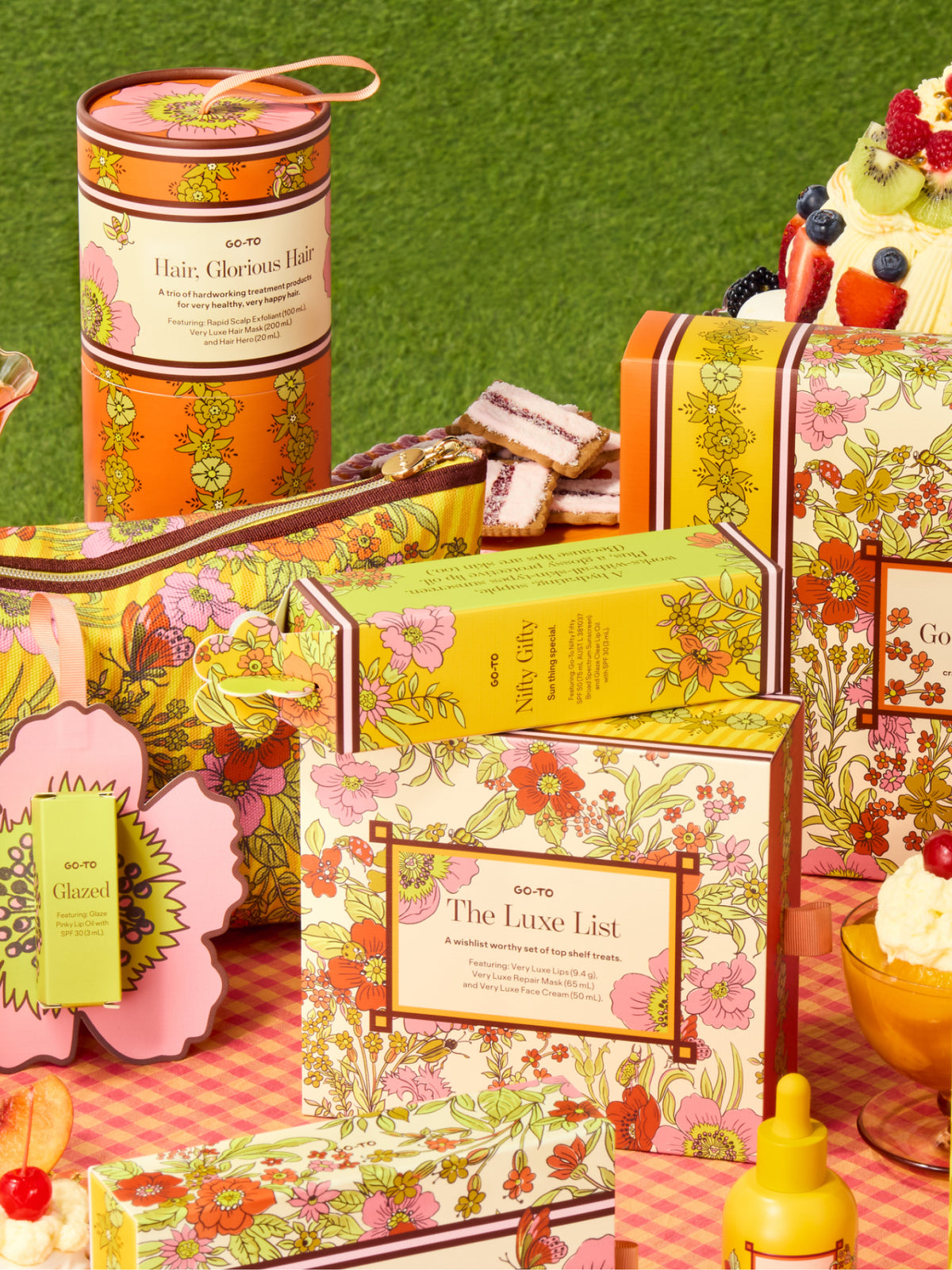 Go-To Skincare gift set display with colorful floral boxes and skincare products arranged on a pink picnic cloth with fruit and summer styling