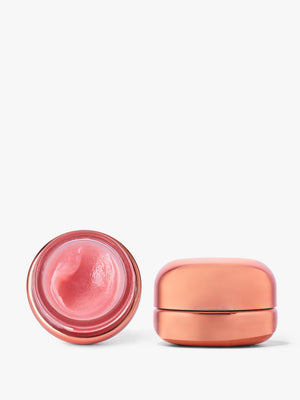 Go-To Skincare Very Luxe Lips pink lip balm in an open glass jar beside its peach colored closed container on a white background