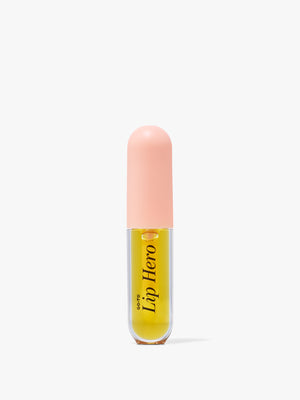 Go To Skincare Lip Hero lip oil in a clear tube with golden yellow formula and a soft pink cap on a white background