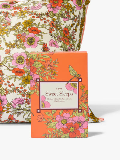Sweet Sleeps floral silk pillowcase in a bright orange Go To Skincare box with a matching floral pillowcase displayed behind it